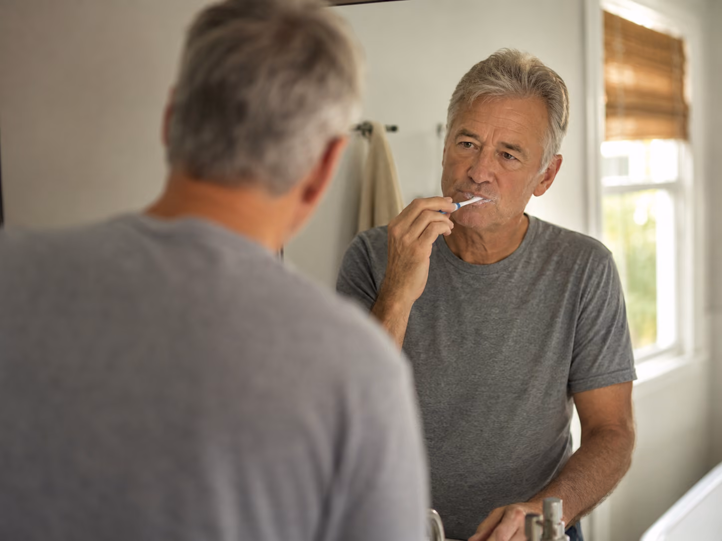 Patient brushing their permanent zirconia All-on-4 teeth during a normal morning routine