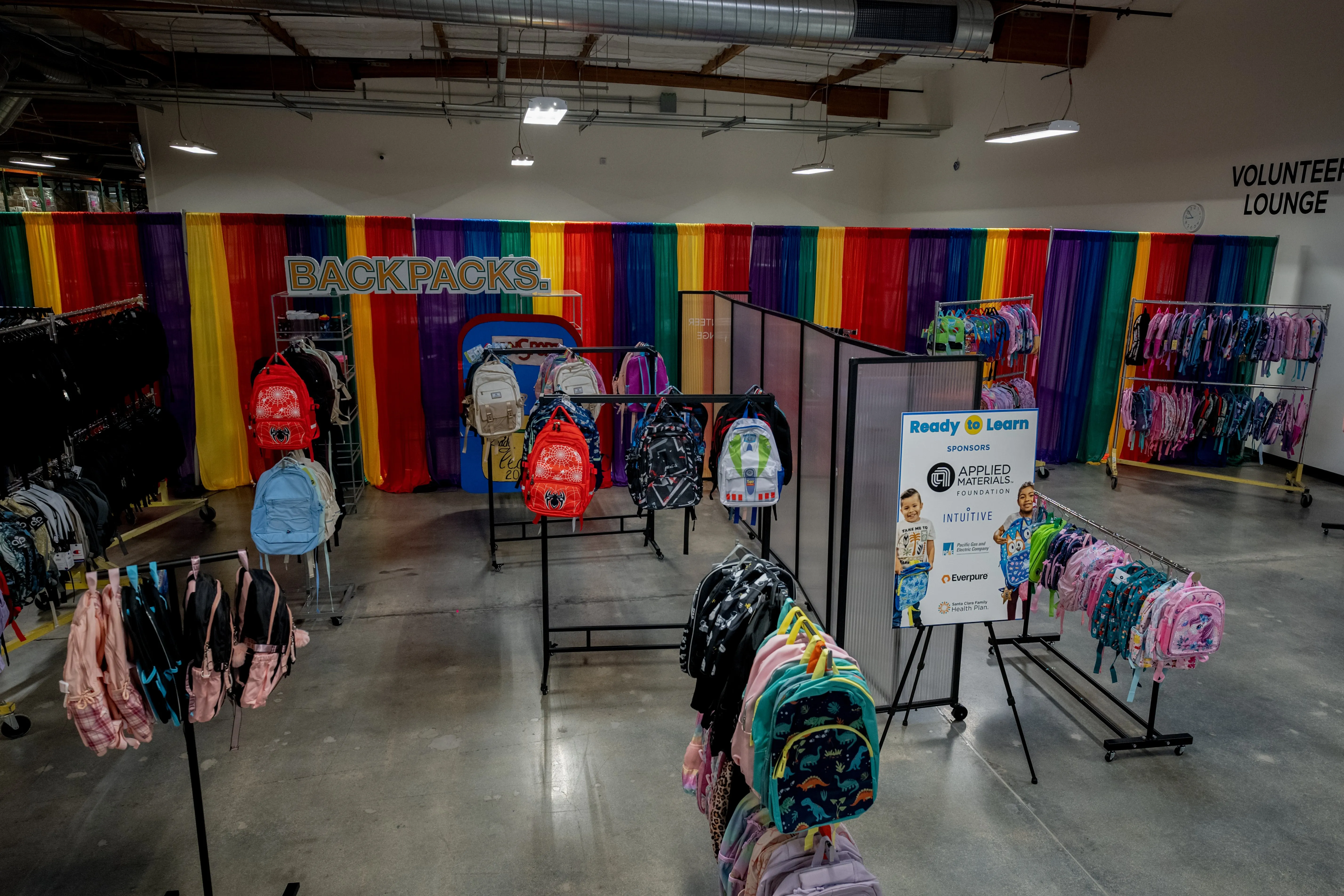 Backpack racks and Ready to Learn sponsor sign at the Sunnyvale Community Services Back to School event