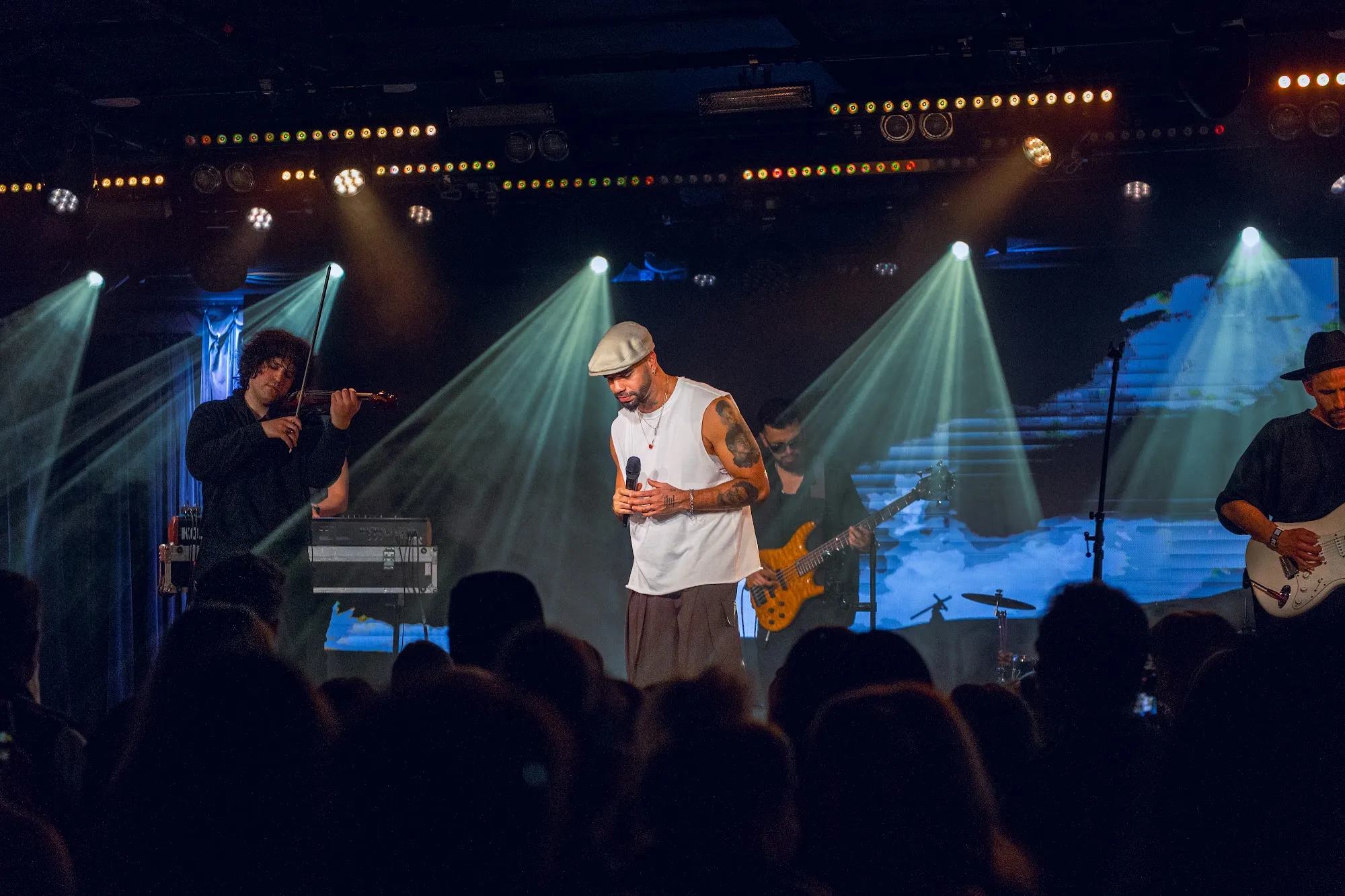 Kállay Saunders on stage under blue light in Budapest