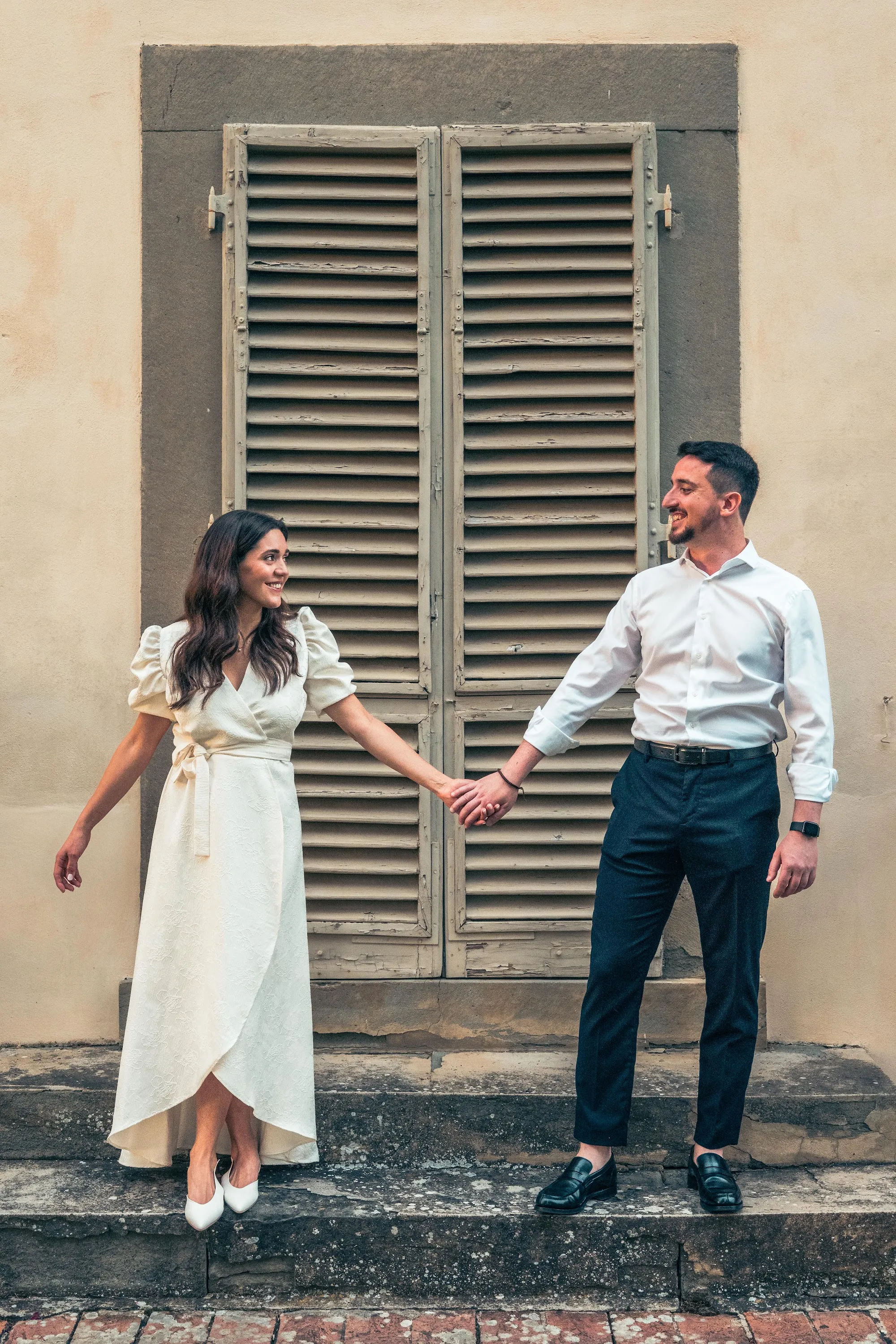 Couple holding hands in front of old shutters at Villa Dianella, wedding photography by GROOVE Media