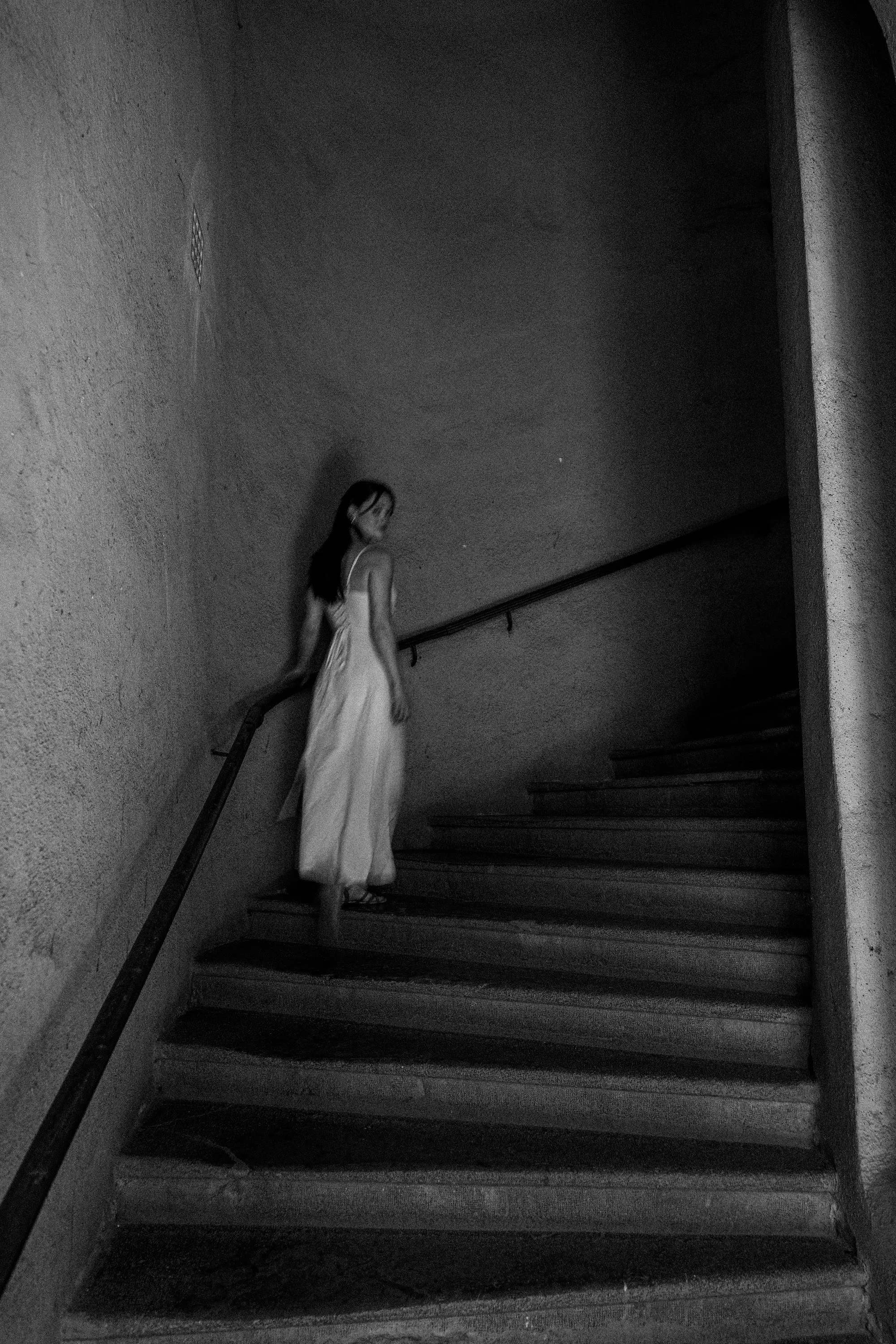 Model Julia at the top of a staircase in black and white, In White editorial by GROOVE Media