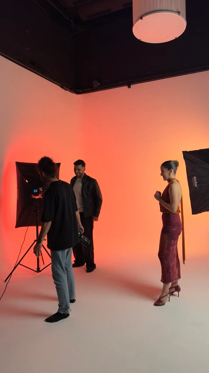 Behind the scenes at a GROOVE Sessions studio shoot, with lights set on a coral backdrop