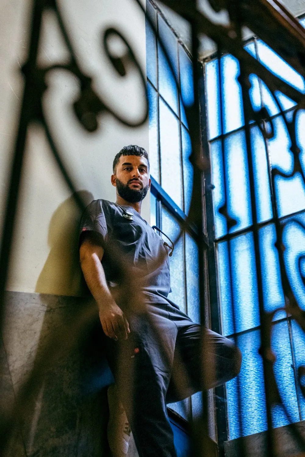 Zoubi in PAX Scrubs framed by an ornate wrought-iron window, PAX Scrubs campaign