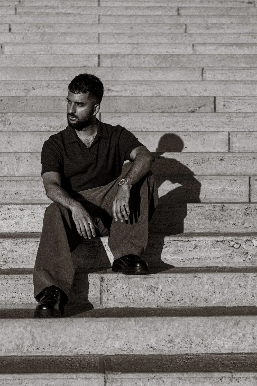 Model Zoubi seated on stone steps in black and white, Parliament Gold editorial
