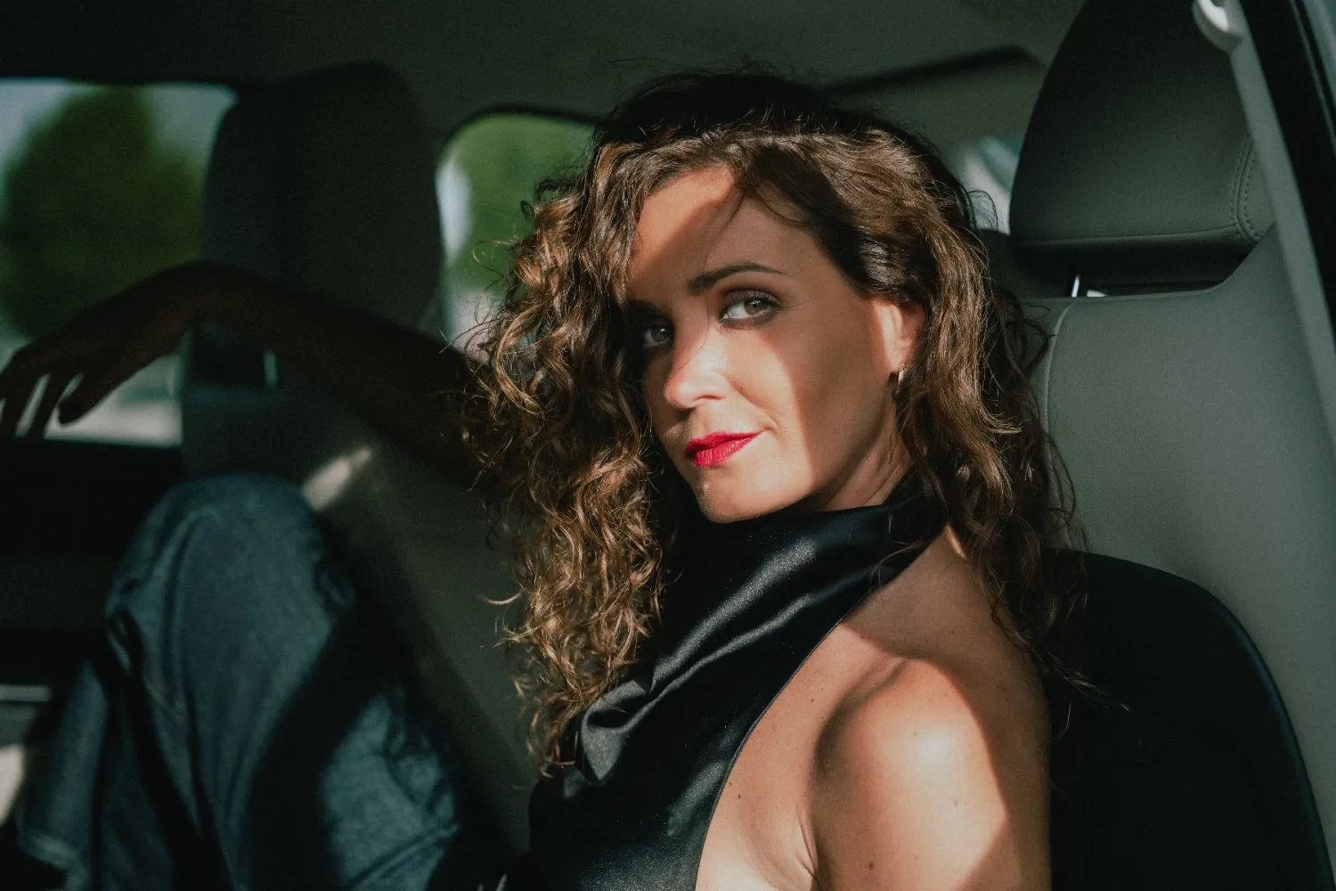 Kinga in red lipstick seated in a car, portrait by GROOVE Media