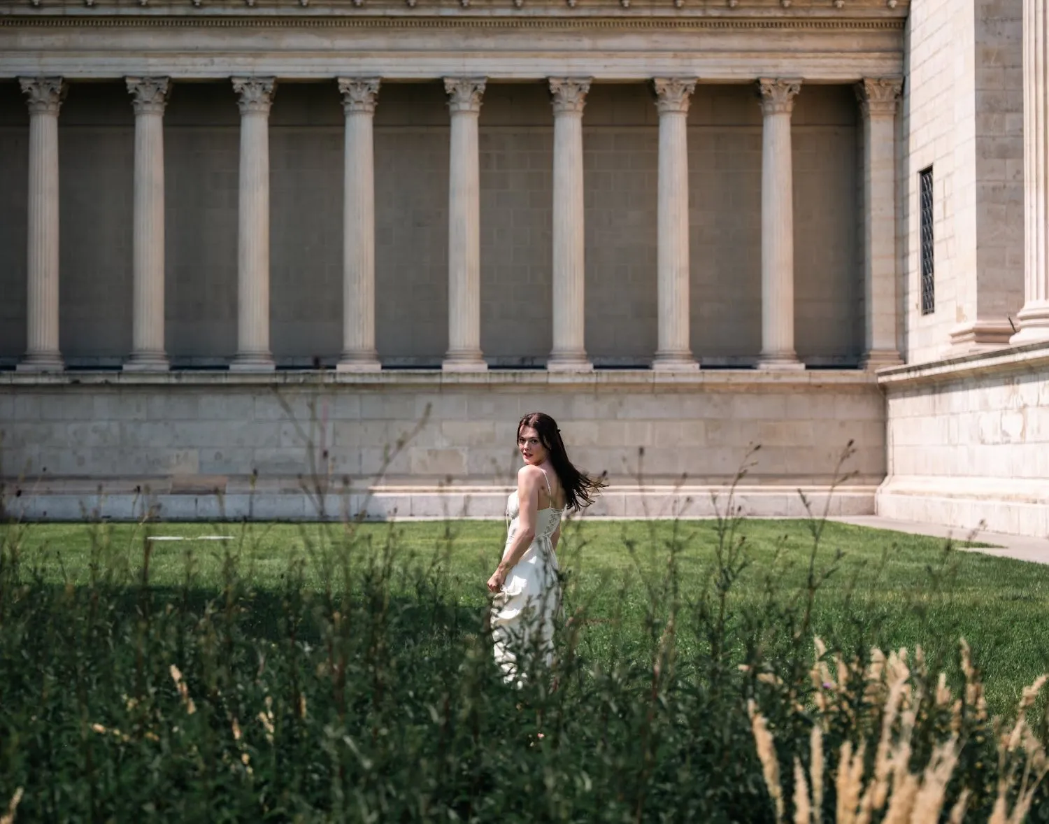 Model Julia in white before a neoclassical colonnade, In White editorial by GROOVE Media