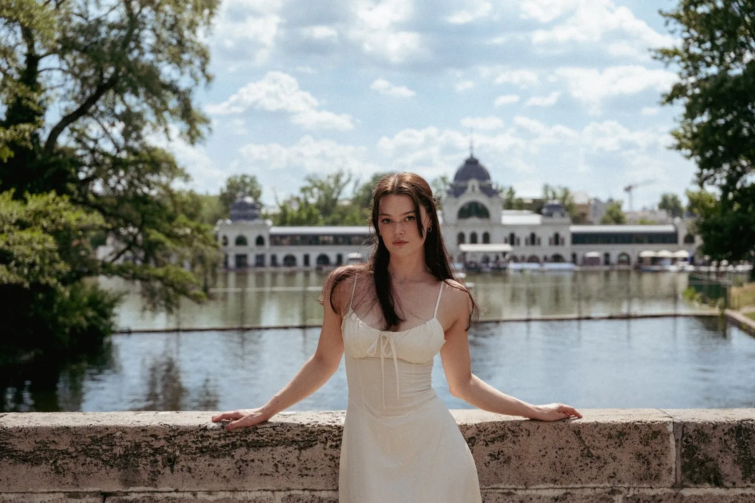 Model Julia at a stone balustrade on a lake, In White editorial by GROOVE Media