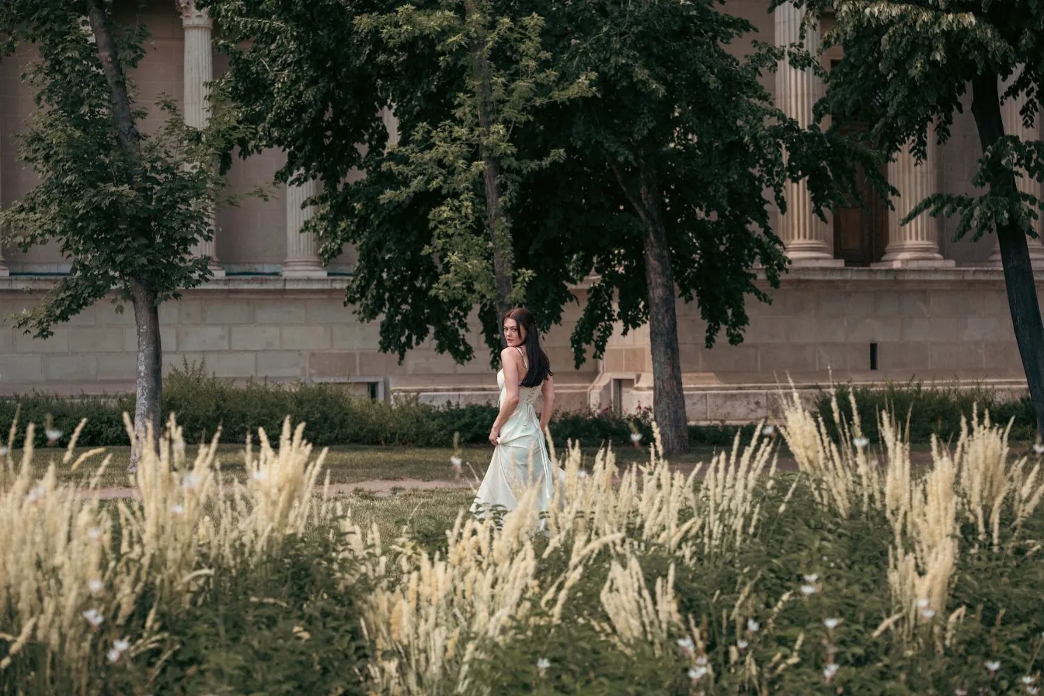 Model Julia among pampas grass below a castle, In White editorial by GROOVE Media