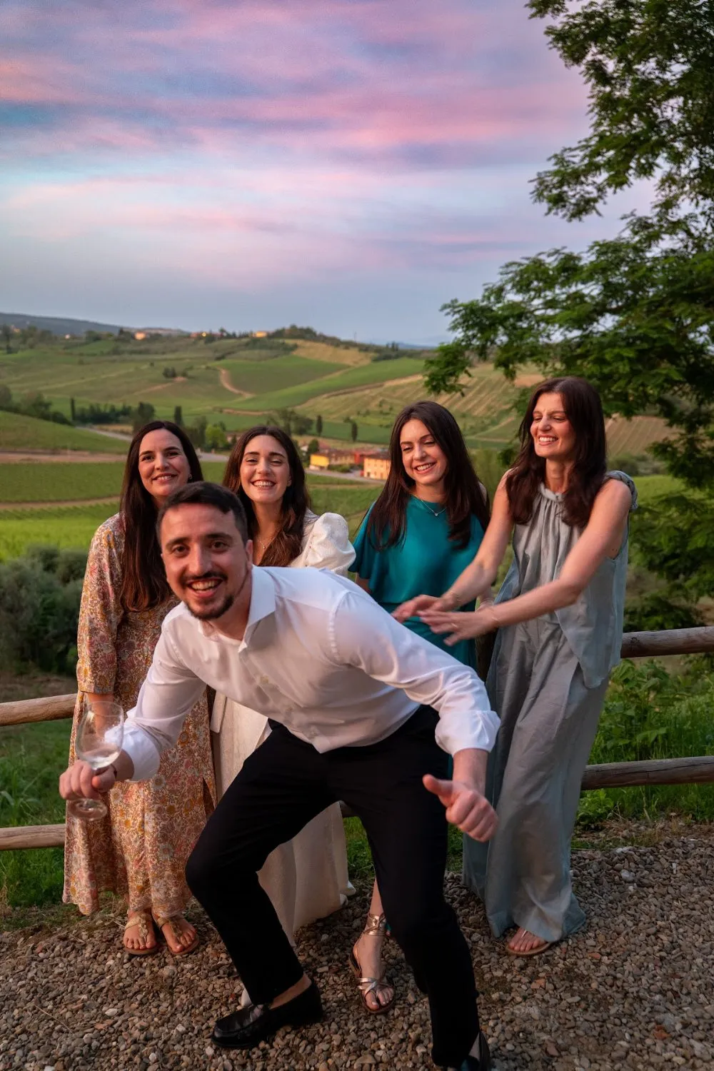 A wedding guest dancing in front of friends above the vineyards at sunset, by GROOVE Media