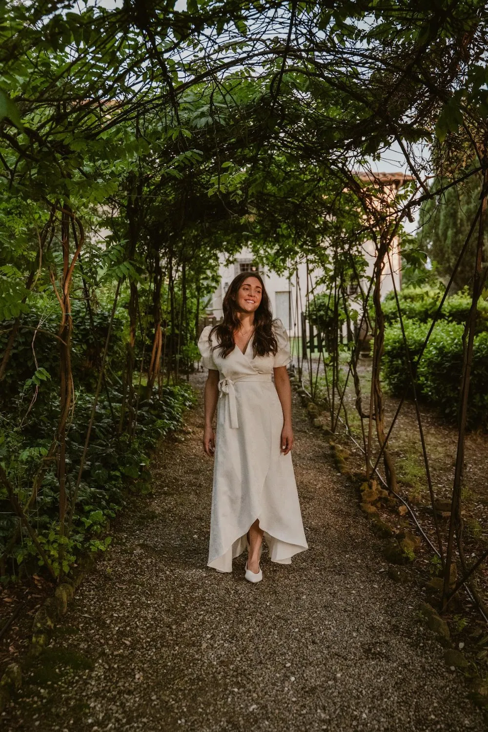 Bride in a white dress under a garden pergola at Villa Dianella, wedding photography by GROOVE Media