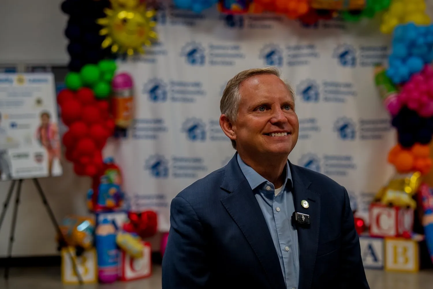 Guest smiling in front of the Back to School balloon backdrop