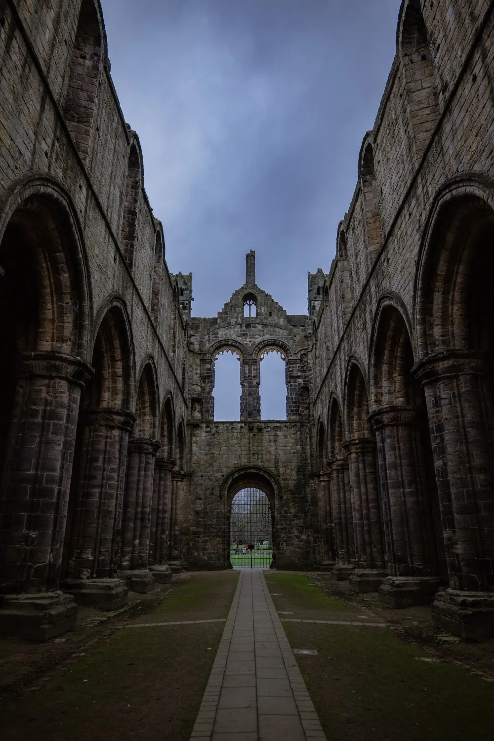 Roofless nave of a medieval abbey ruin under a cloudy sky, UK, photographed by GROOVE Media