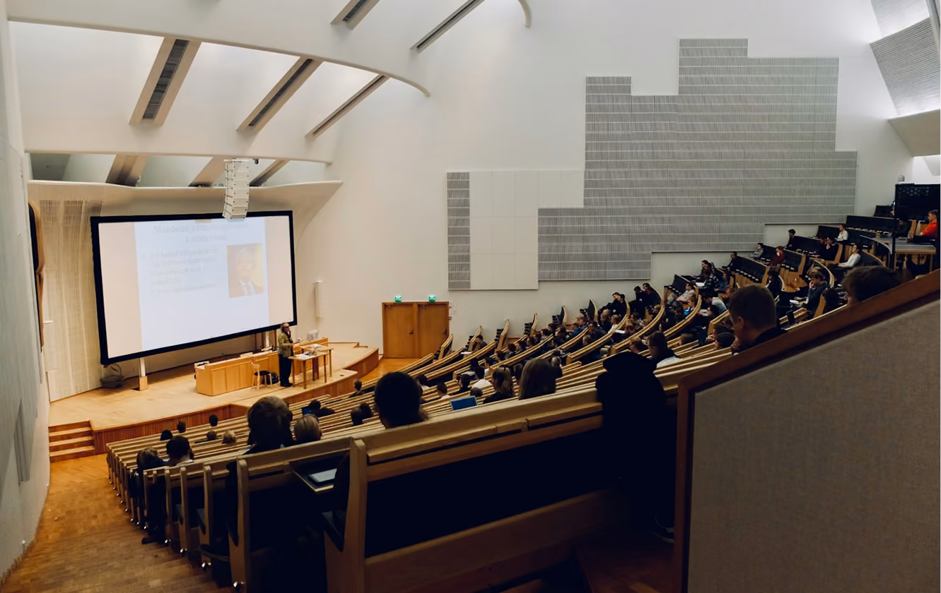Hörsaal mit Studierenden vor einer großen Projektionsleinwand