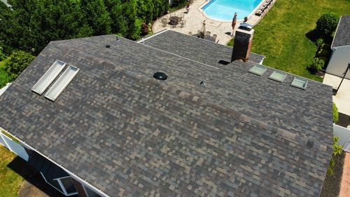 Aerial view of a completed asphalt shingle roof with skylights on a Huntington home