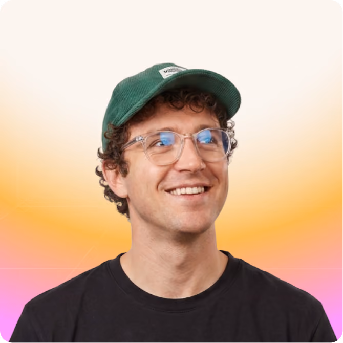 Smiling partner marketing manager with curly hair, clear glasses, green cap, and black shirt on light beige background.