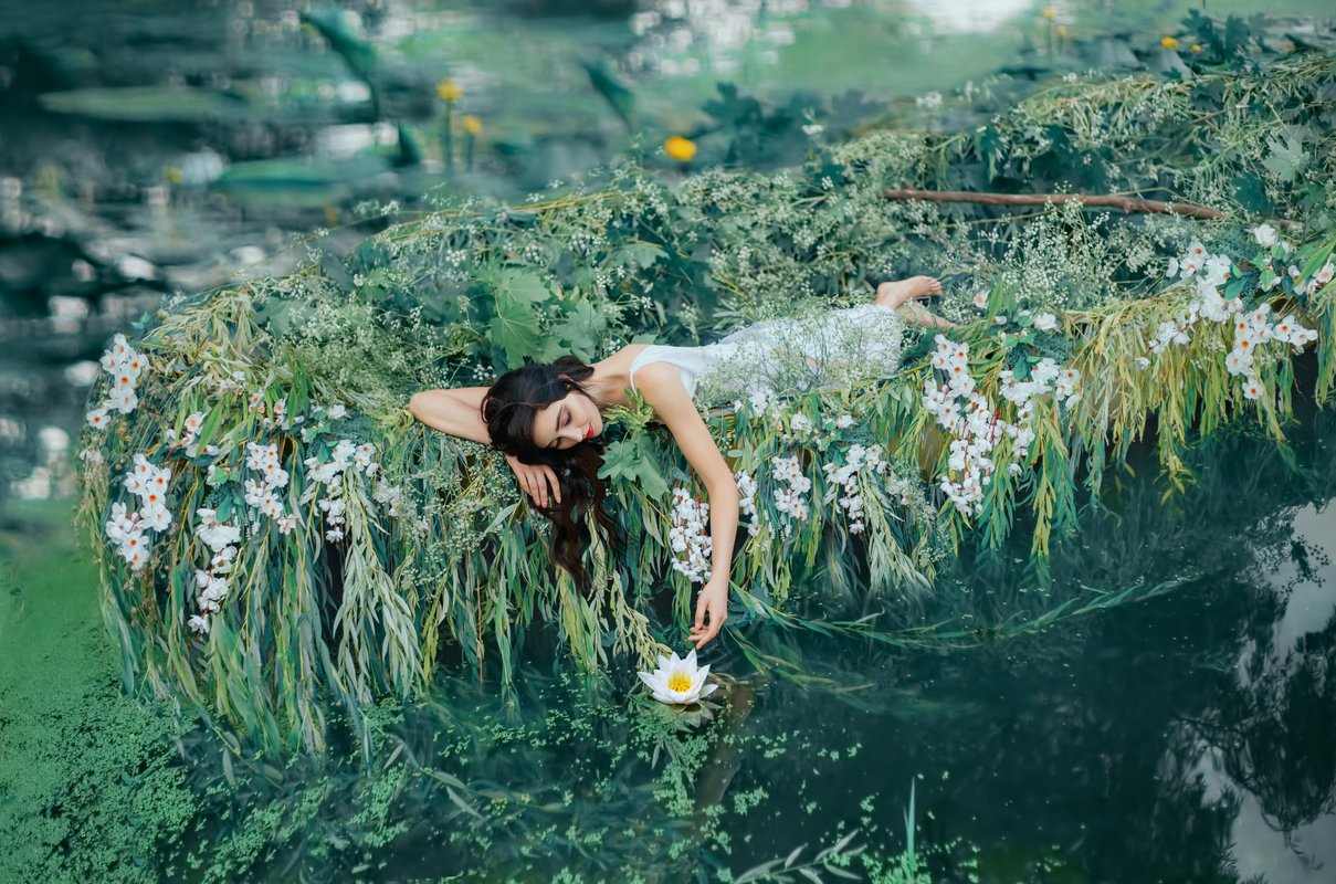 Une femme couchée sur un lit de verdure