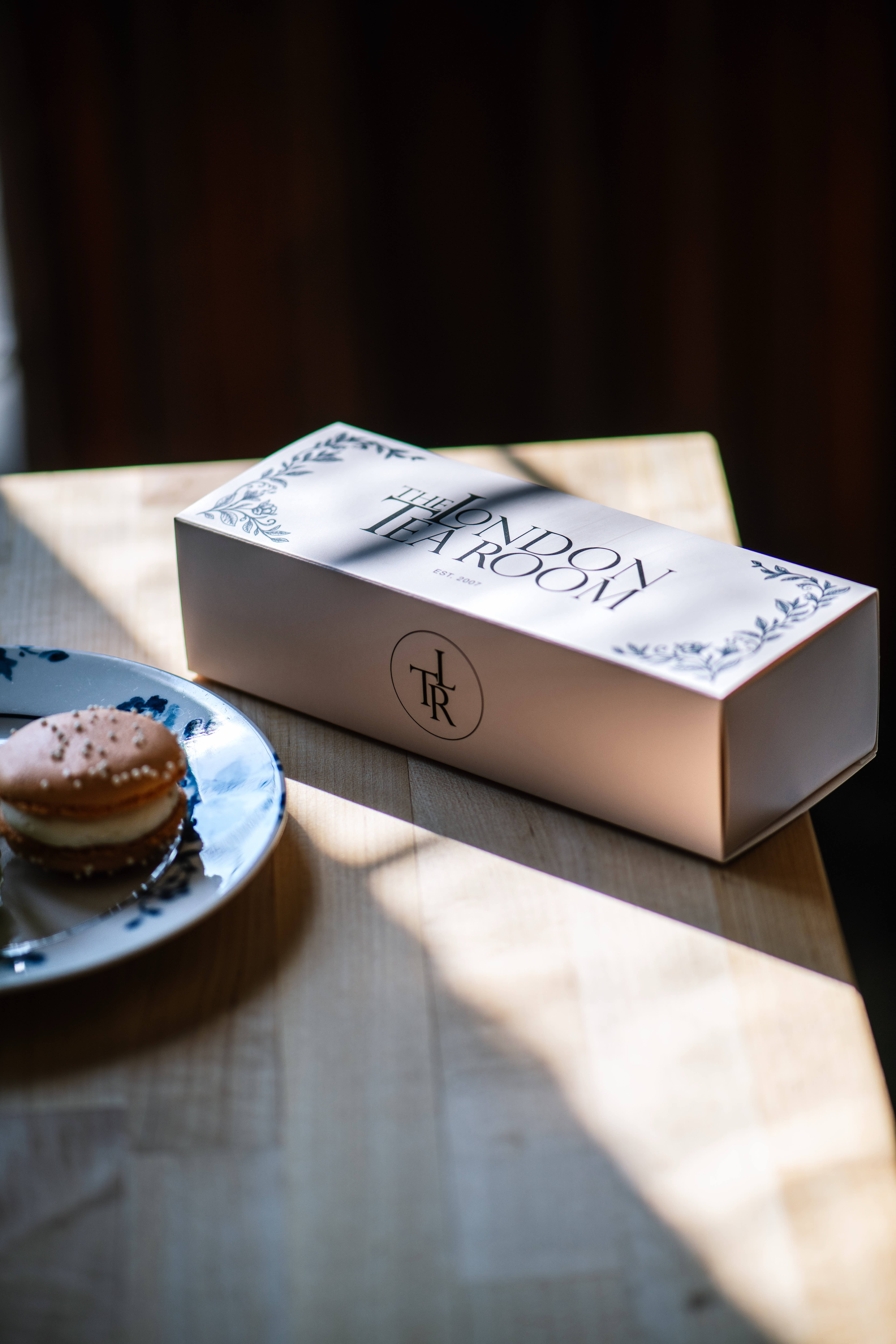 A London Tea Room patisserie box with a macaron on china