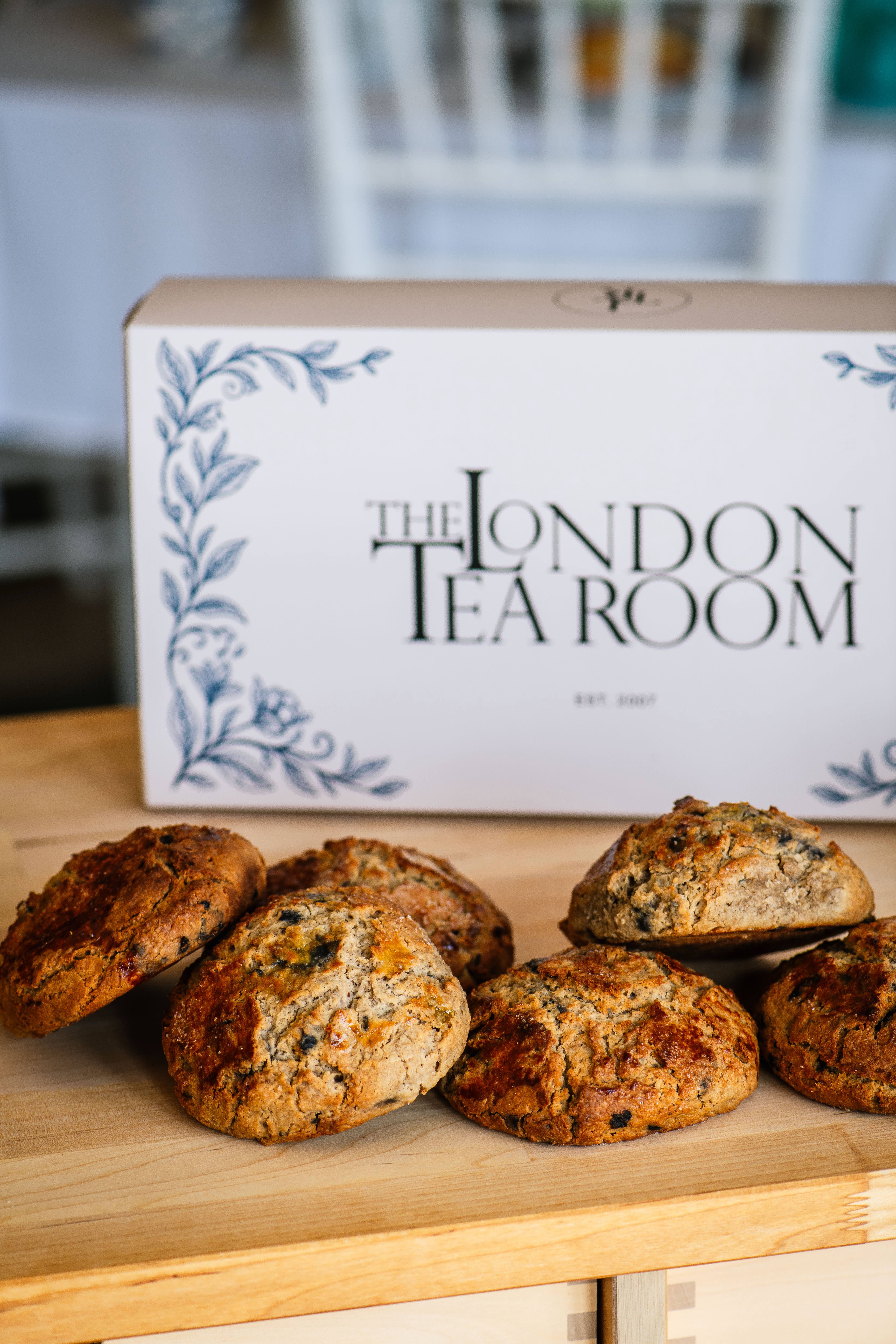 Freshly baked scones beside a London Tea Room bakery box