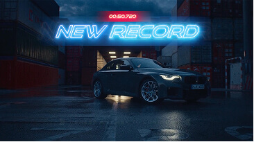 Dark sports car parked on wet pavement under neon signs reading New Record and 00:50.720 time.
