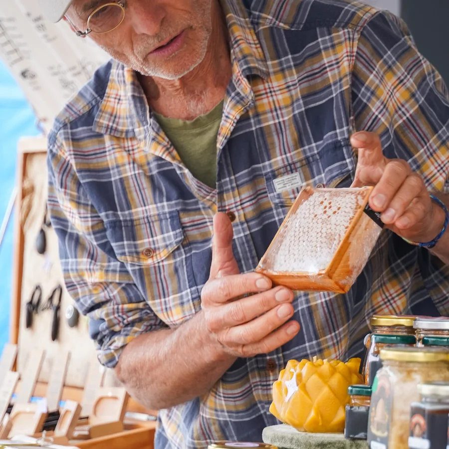 A honeycomb frame held at a market stall