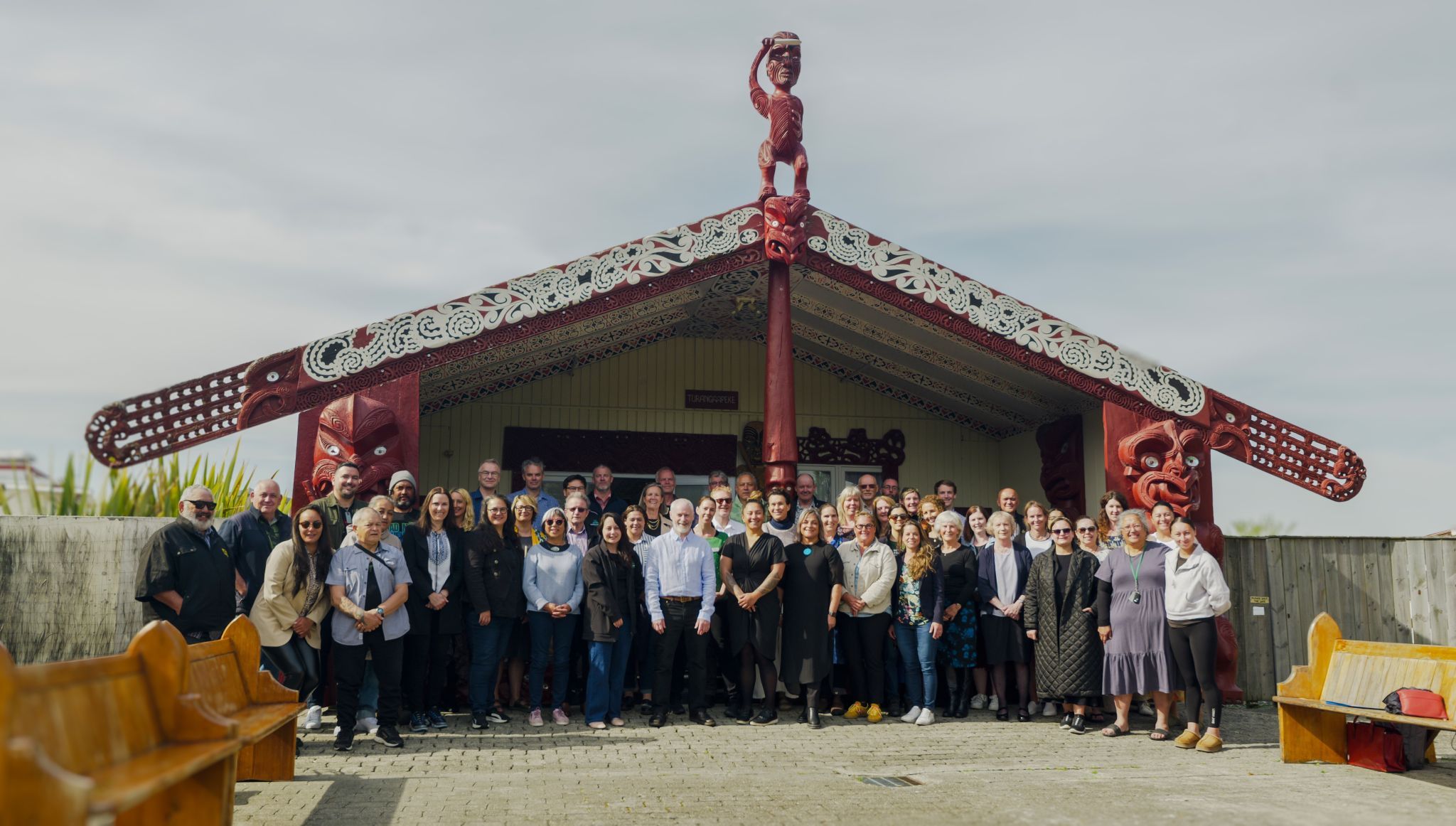 Conference participants gathered in front of the wharenui
