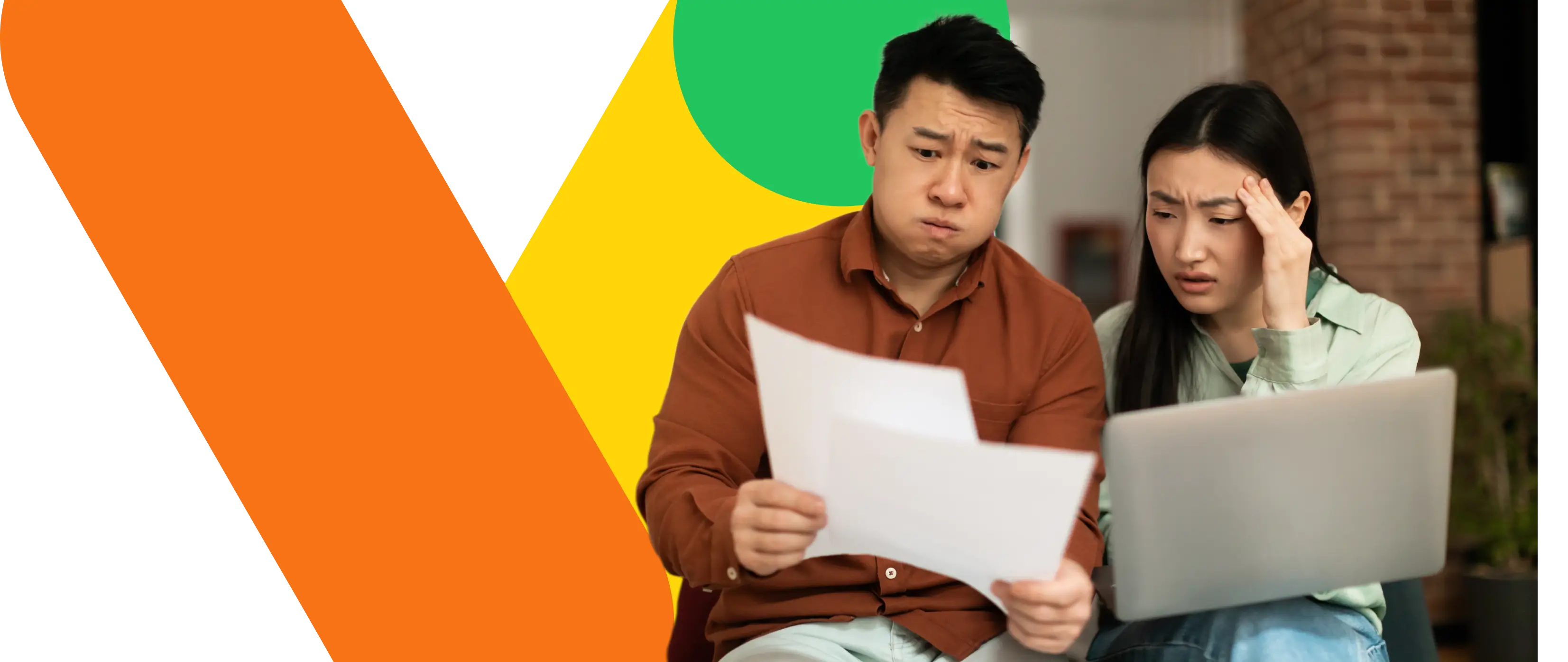 Man and woman look worried while reviewing papers and using a laptop together indoors.