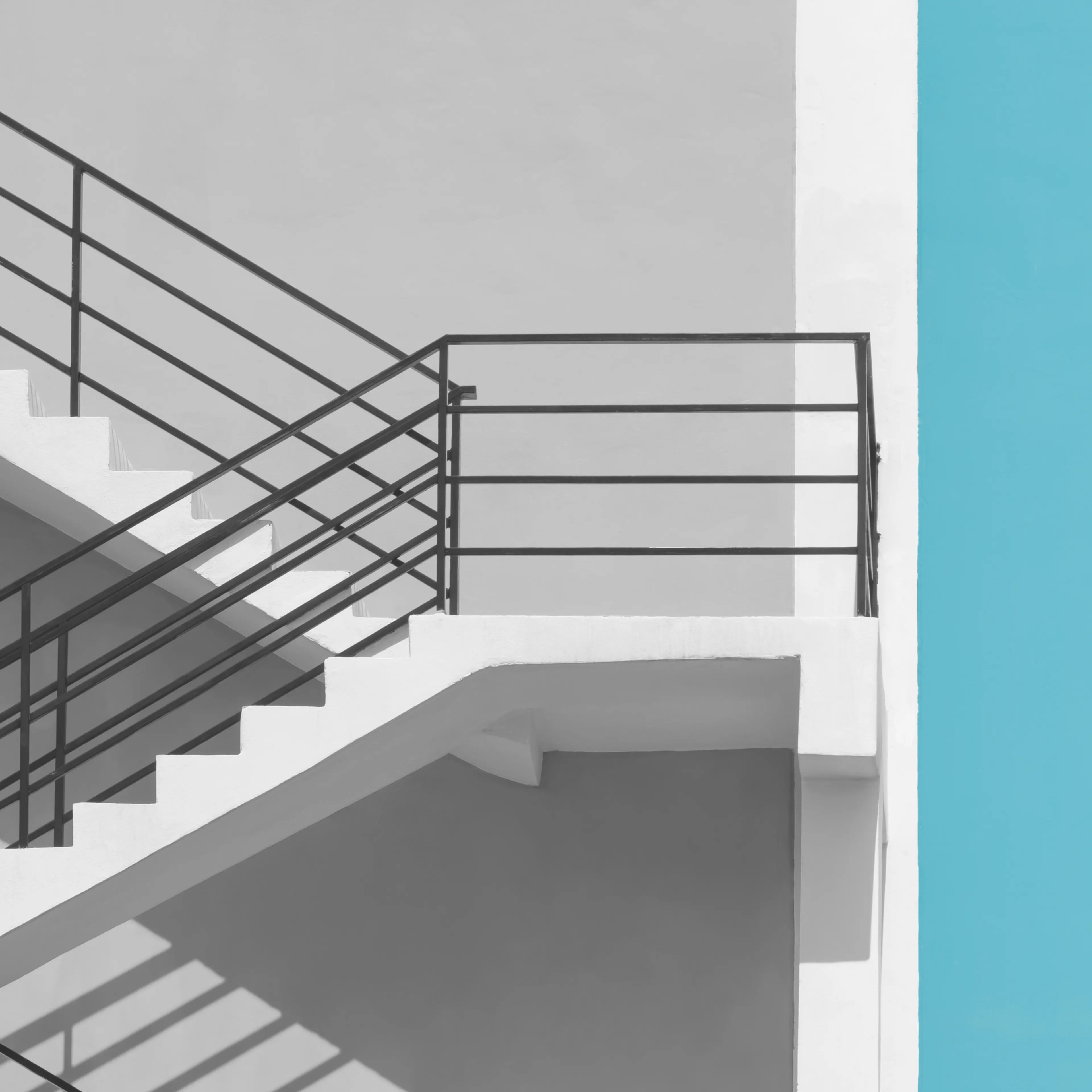Staircase going up with a blue strip on the right side of the staircase.