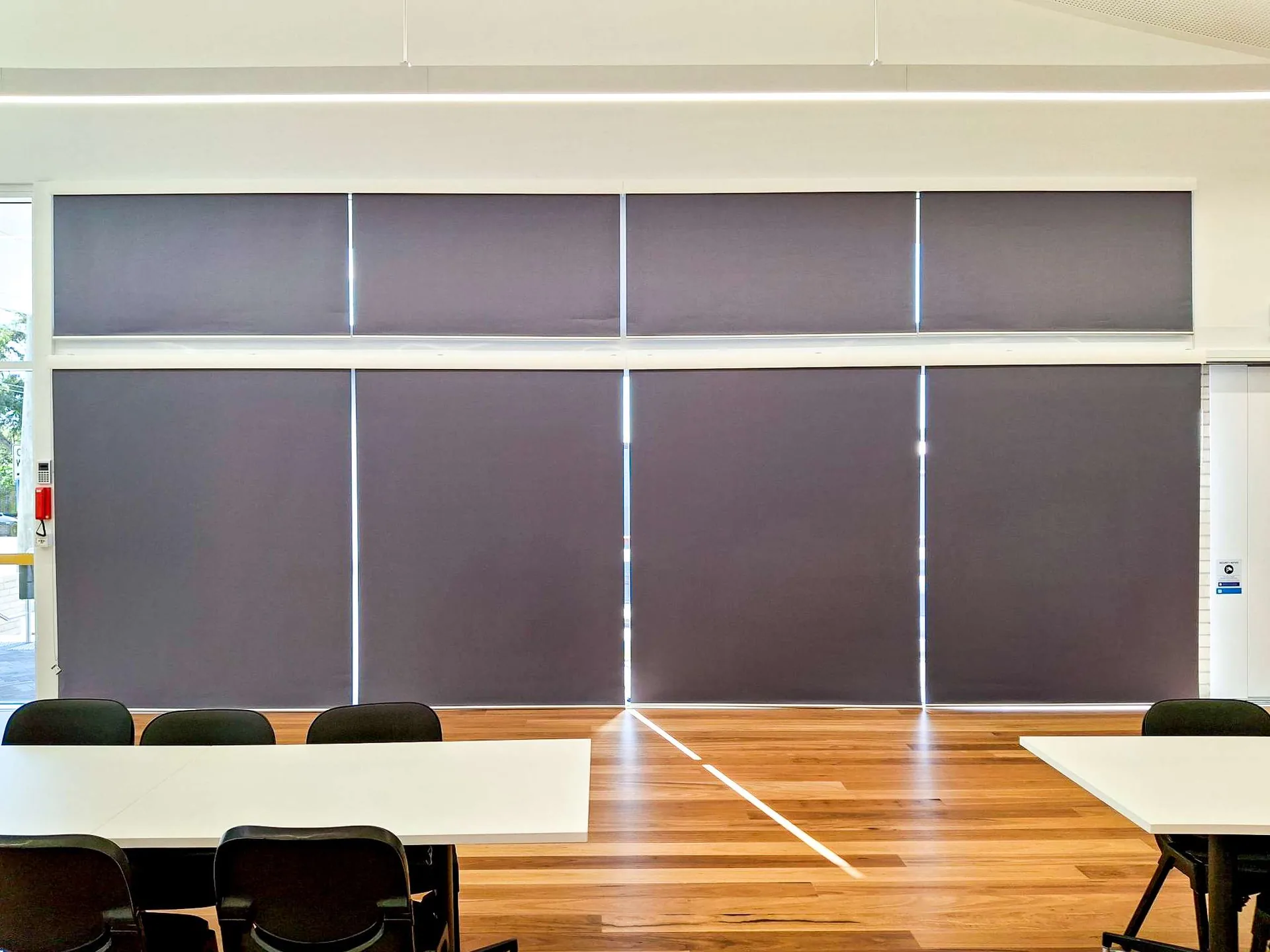 A wall of custom blockout roller blinds installed by the Quicksew team