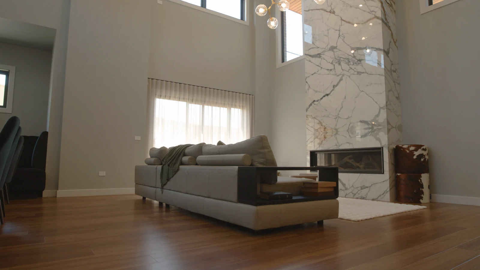 Sheer curtains on the tall windows of a double-height living room with a marble fireplace, by Quicksew