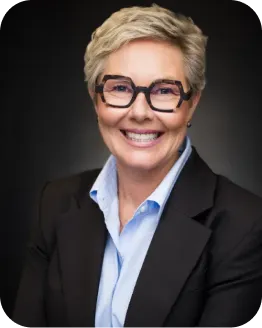 Portrait of Megan Crum wearing glasses and a dark blazer