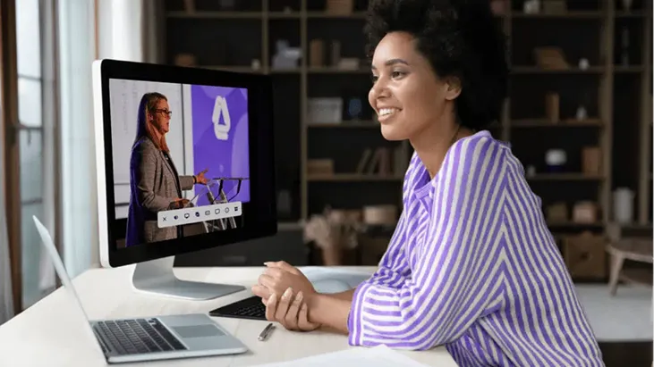 Remote attendee watching a live streamed conference session on a desktop computer