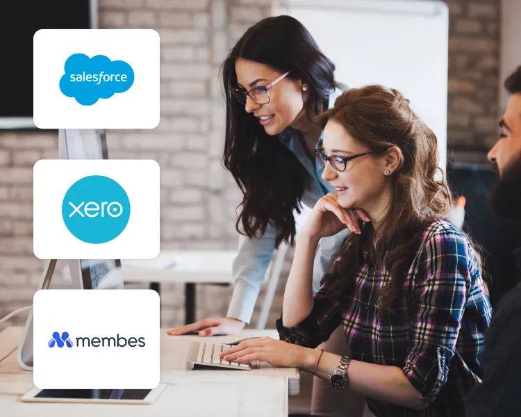 Two colleagues working at a computer, with Salesforce, Xero and Membes integration logos alongside