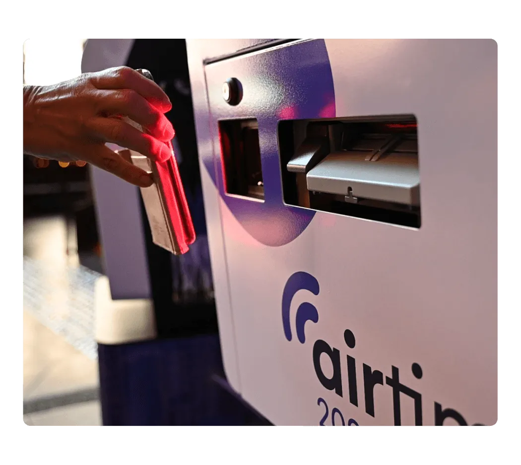Attendee collecting a printed name badge and lanyard from a self-service check-in kiosk