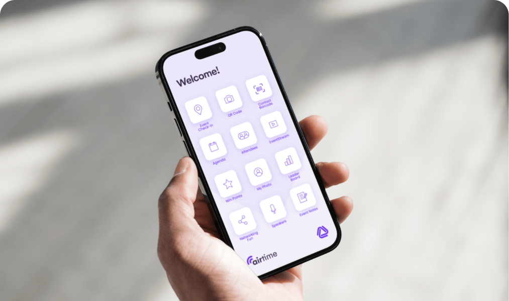 Hand holding a phone showing an event app home screen of agenda, networking and survey tiles