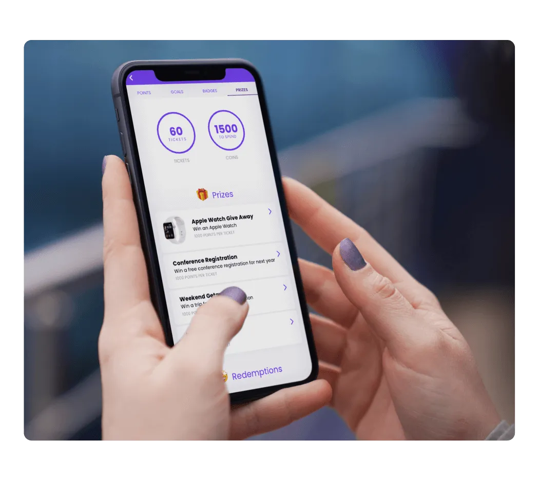 Hands holding a phone showing an event app prize and points screen with tickets and coins