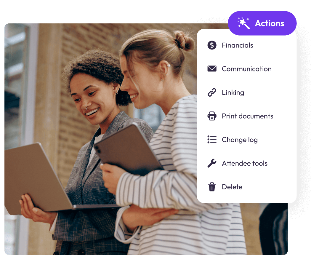 Two event planners looking at a laptop beside an attendee record Actions menu of financials, communication and attendee tools