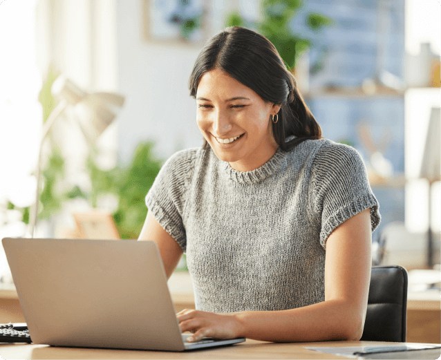 Event marketer smiling while working on a laptop at a desk