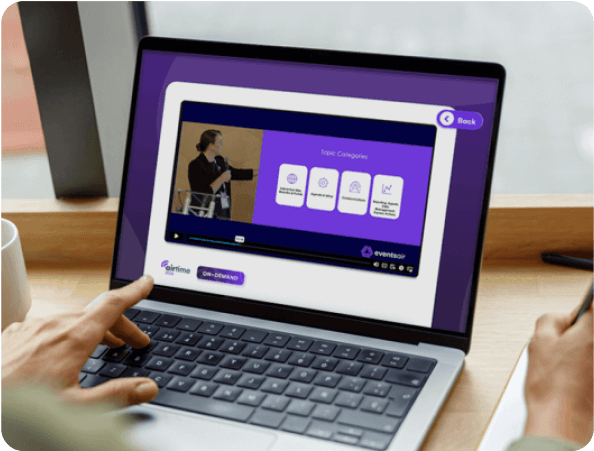 Laptop showing an EventsAir virtual event portal with a session video and topic categories