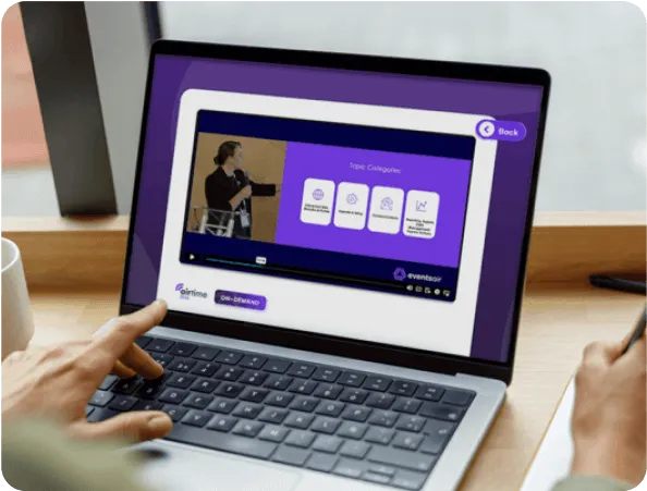 Laptop showing an EventsAir virtual event portal with a session video and topic categories
