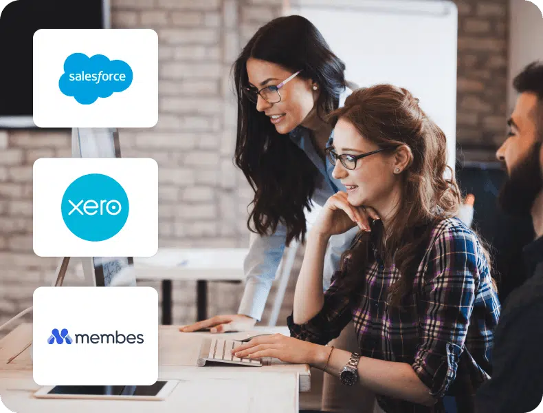Colleagues working at a computer beside Salesforce, Xero and Membes integration logos