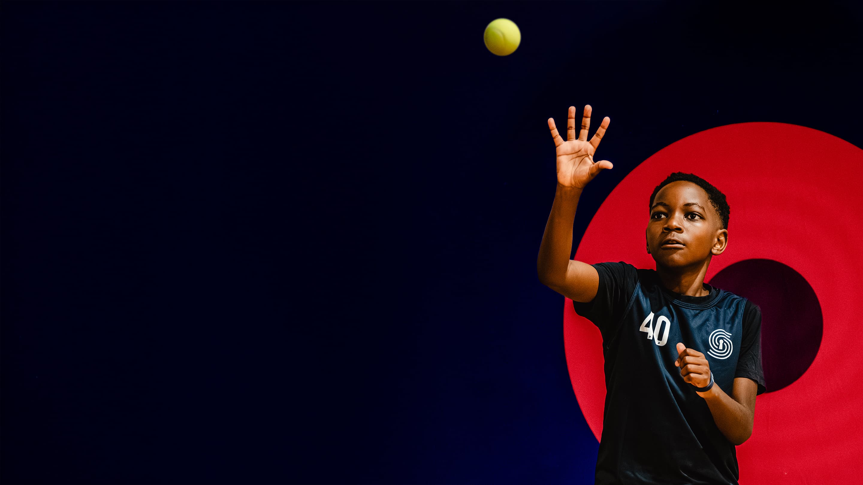 Young athlete in a numbered jersey reaching to catch a ball during a SportsKey assessment