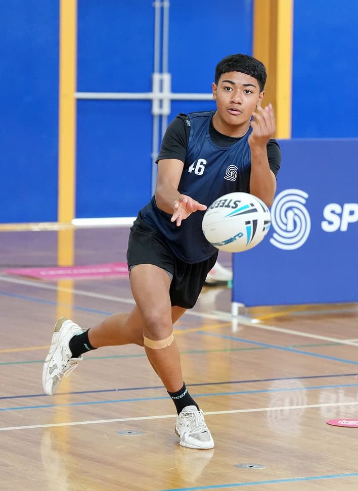Young athlete catching a ball during an indoor SportsKey testing session, wearing jersey number 6