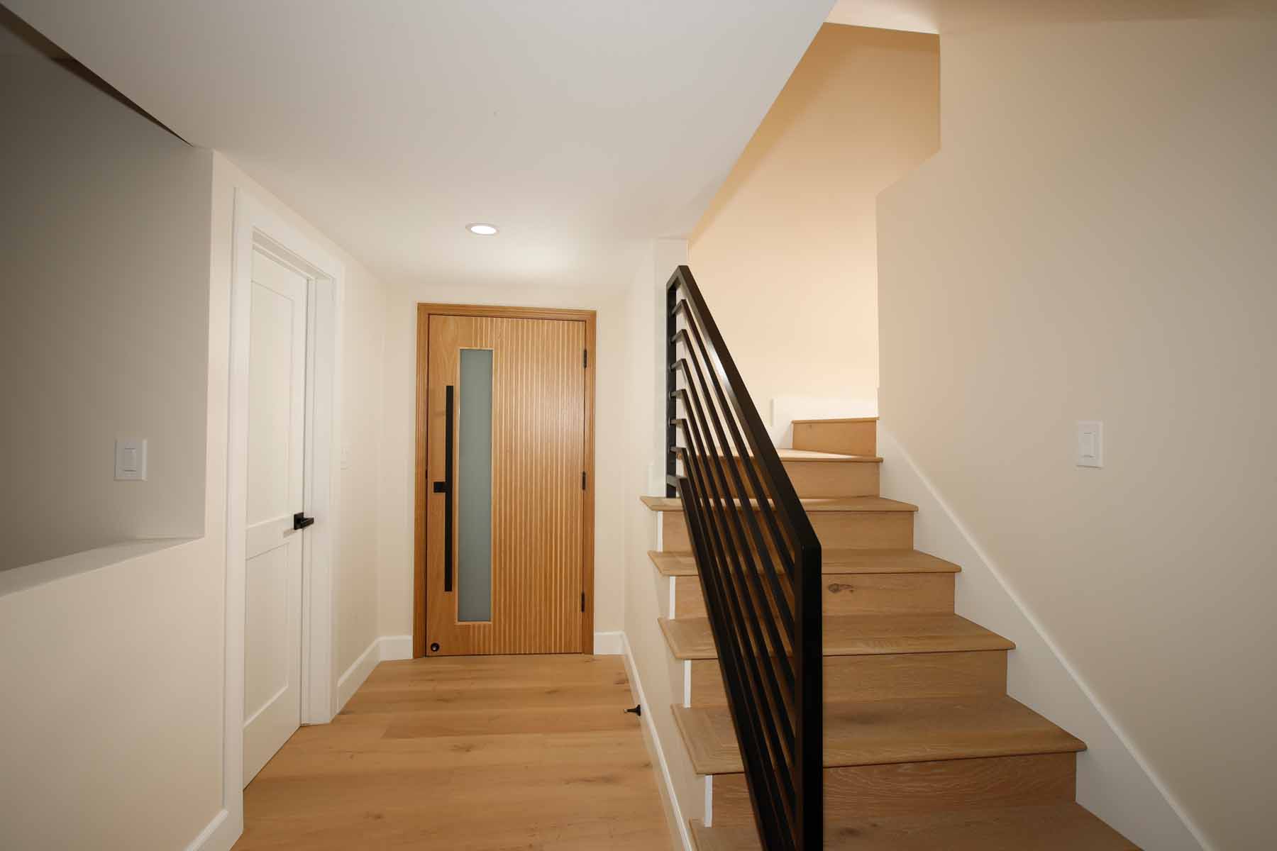 Entry foyer with white oak floors and modern staircase at 19939 Hemmingway Street, Winnetka, Los Angeles