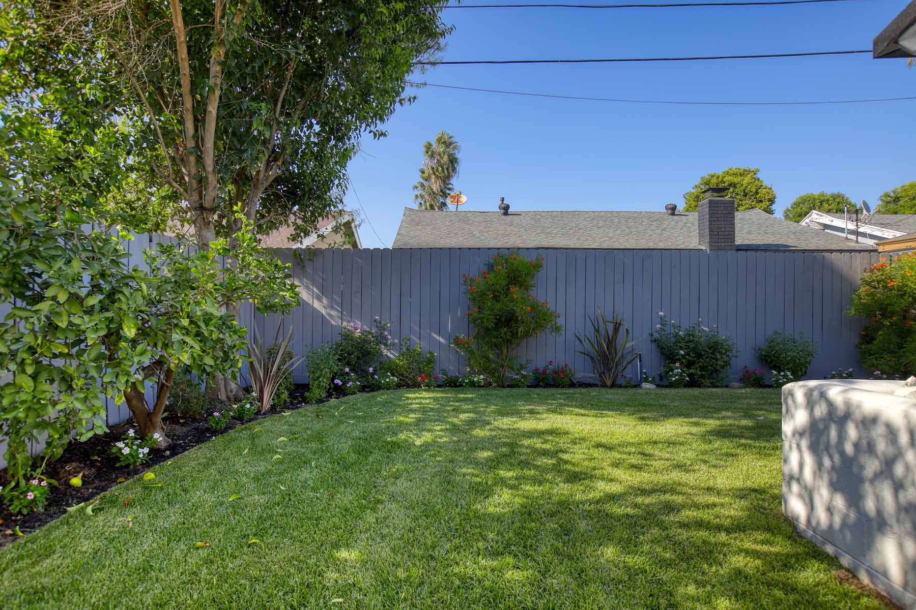 Private backyard lawn with mature landscaping at 19939 Hemmingway Street, Winnetka, Los Angeles