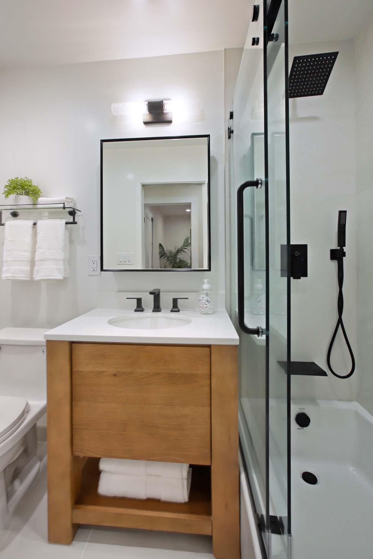 Full bathroom vanity with open shelving and rainfall shower at 19939 Hemmingway Street, Winnetka