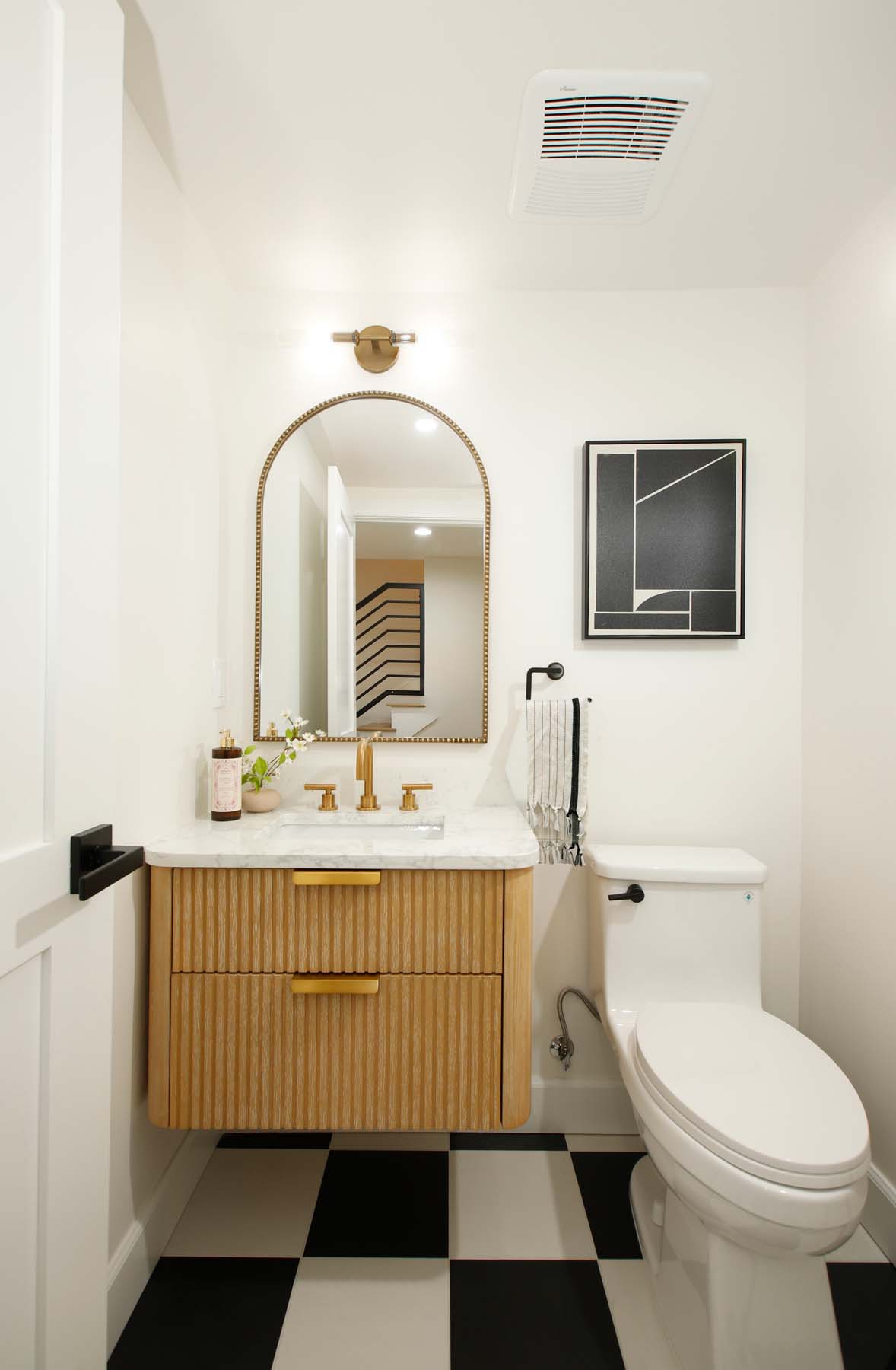 Polished powder room with checkered tile floor, fluted vanity, and brass fixtures at 19939 Hemmingway Street, Winnetka