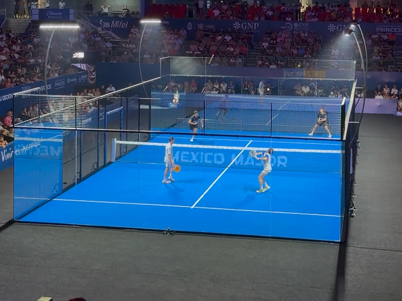 Partido de pádel con público lleno en un torneo deportivo nocturno