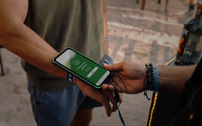 Pago cashless en playa: cliente paga con brazalete RFID escaneado por celular
