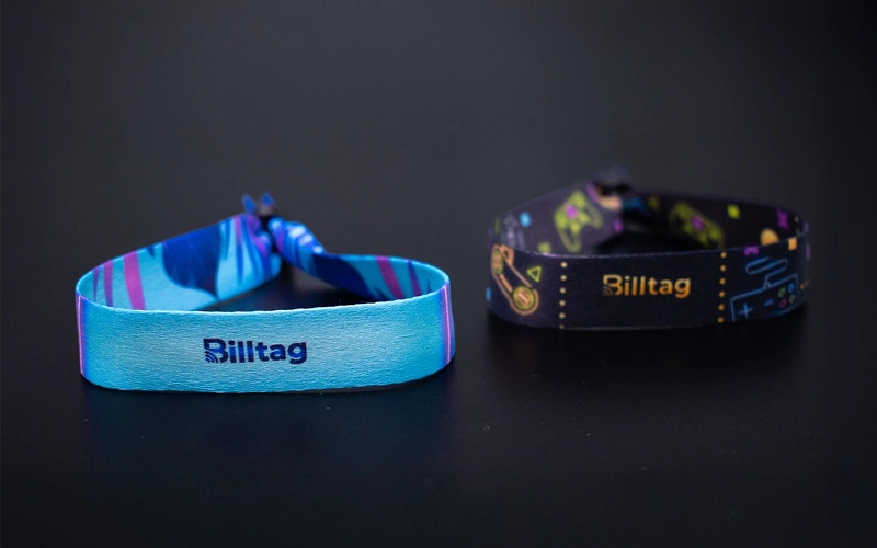 Dos brazaletes RFID Billtag con diseños de colores sobre fondo negro
