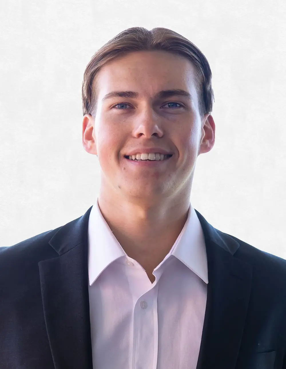 Smiling young man with brown hair wearing a dark suit jacket and white dress shirt.